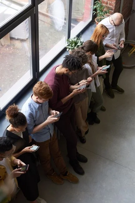 innovative Hands using smartphone beside laptop with stock charts, showcasing digital trading.