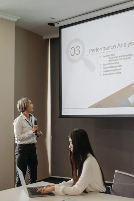 our-story Person analyzes stock data with a smartphone and laptop, indoors.