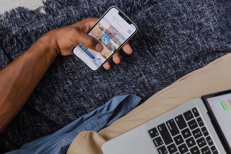 creative-03 Person using smartphone for stock market analysis at home office.