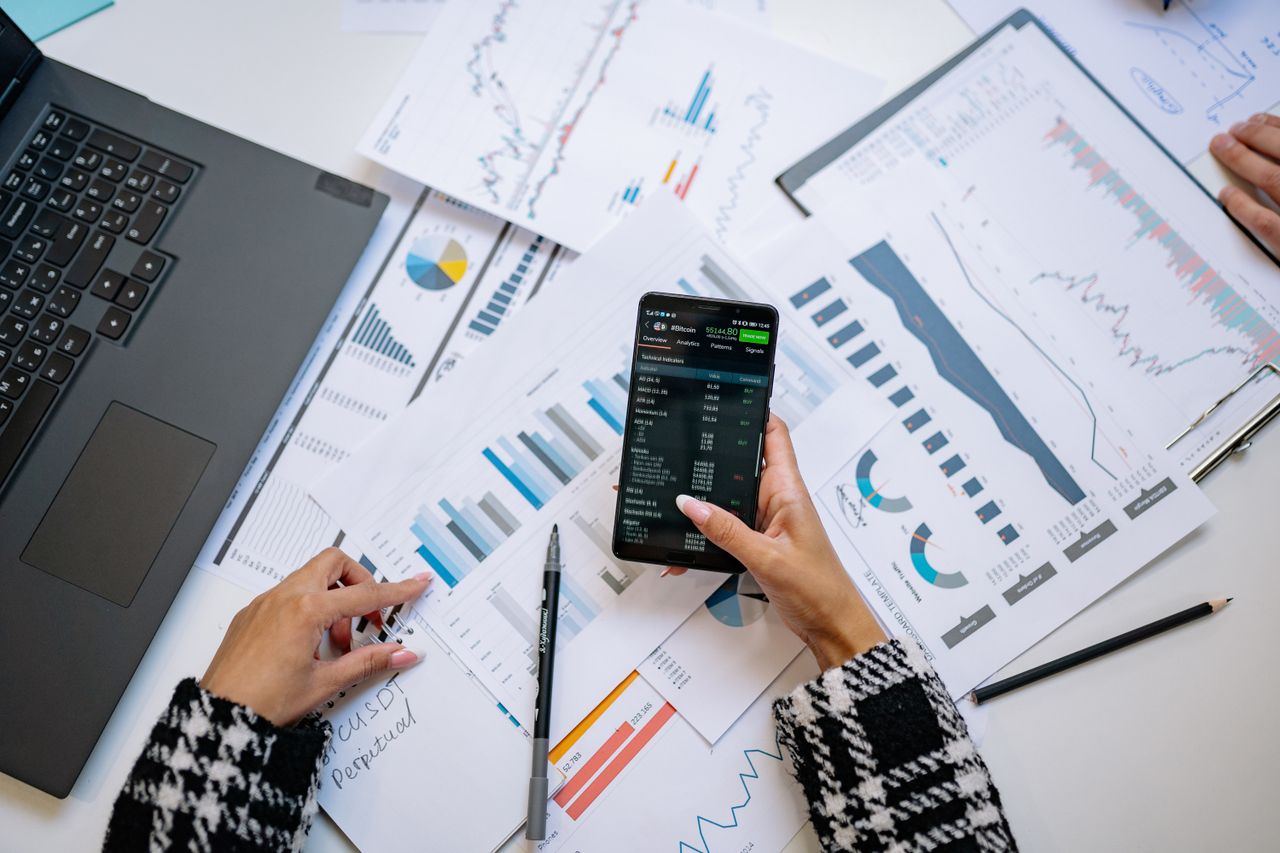 Services-02 A bird’s-eye view of charts and a smartphone in an office, highlighting data analytics.